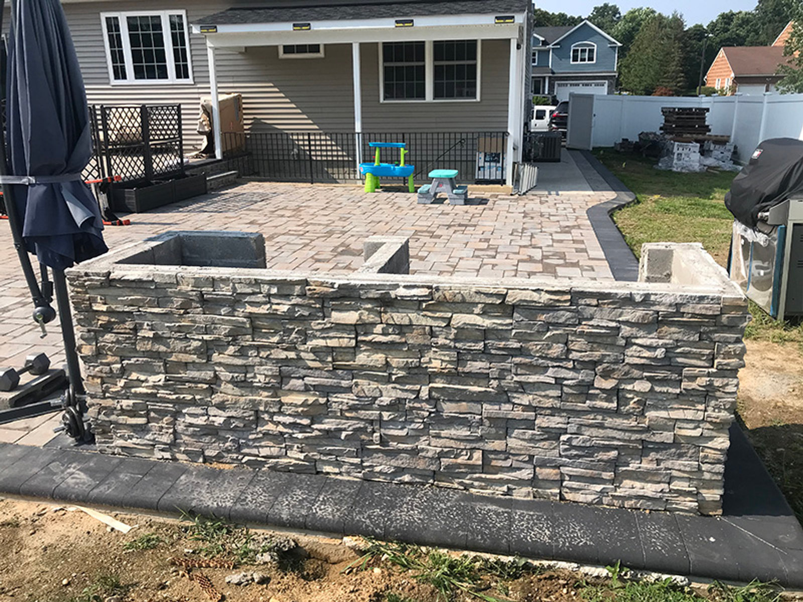Cultured stone retaining wall bordering a paver patio